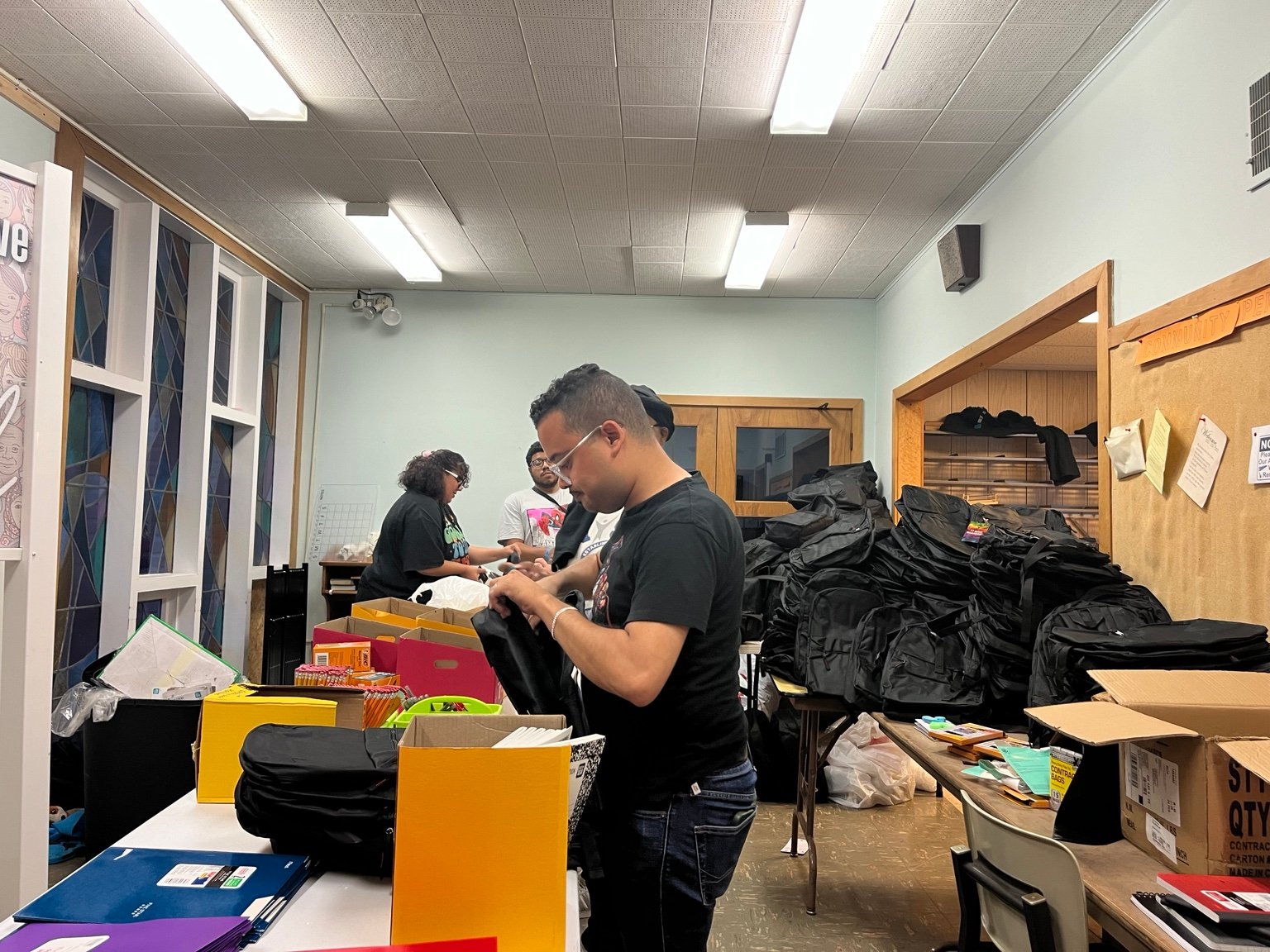 Volunteers preparing backpacks and school supplies