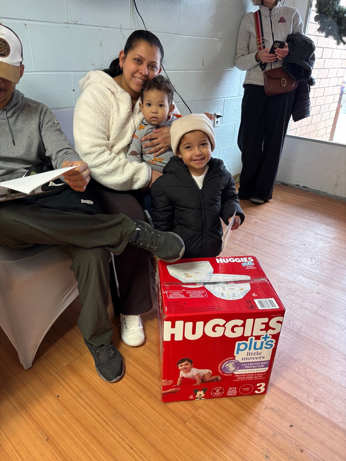 A family gathered beside diapers and baby essentials