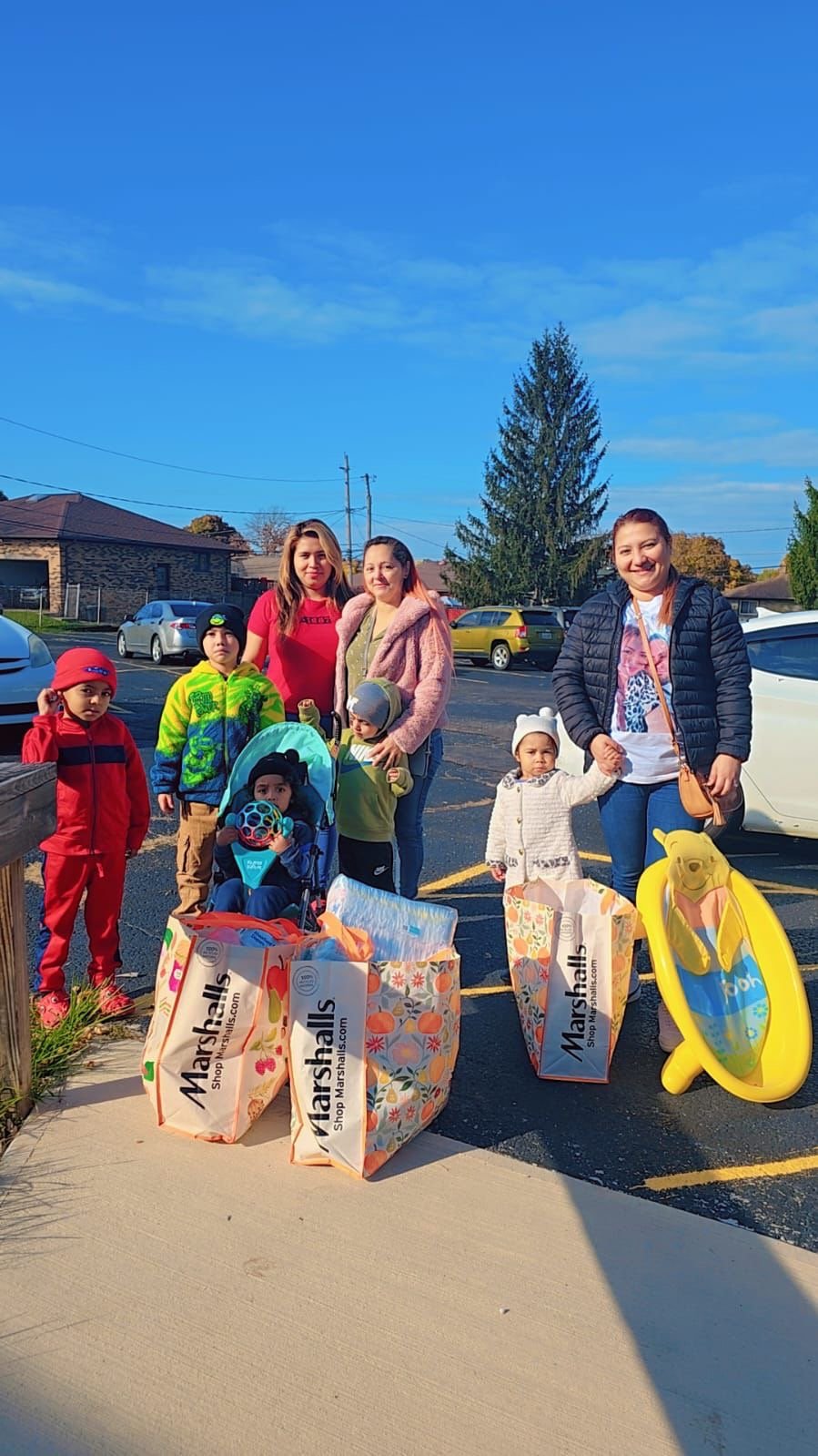 Community members gathered outdoors with family essentials